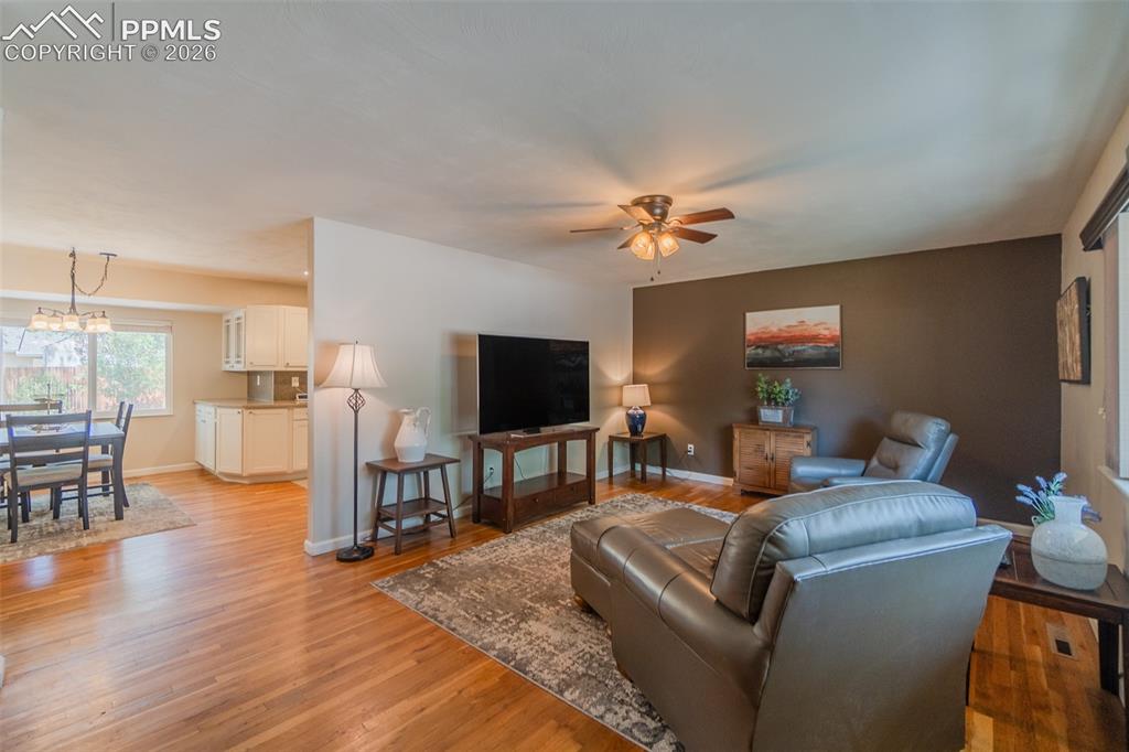 Image 6 of 30: Open-concept living space featuring wood-finish flooring, a ceiling fan, an