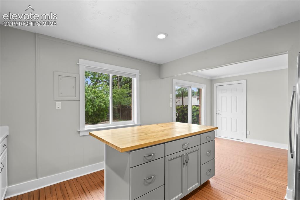 Image 10 of 31: Kitchen featuring a central island with a wood-finish countertop, gray cabi