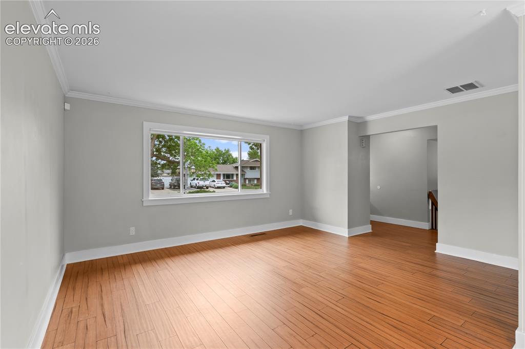 Image 14 of 31: Spacious room featuring wood-finish flooring, light gray wall paint, white