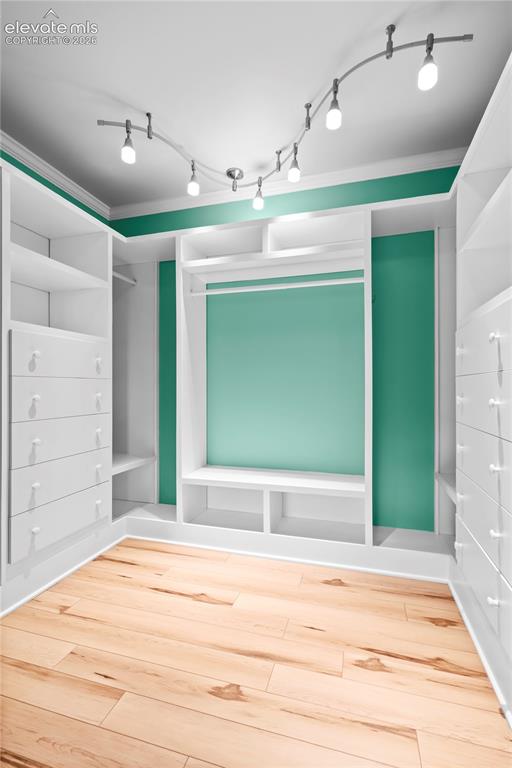 Image 20 of 31: Custom closet system featuring built-in shelving, drawers, and hanging rods