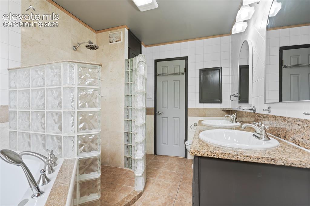 Image 21 of 31: Bathroom featuring a dual vanity with granite countertops and undermount si