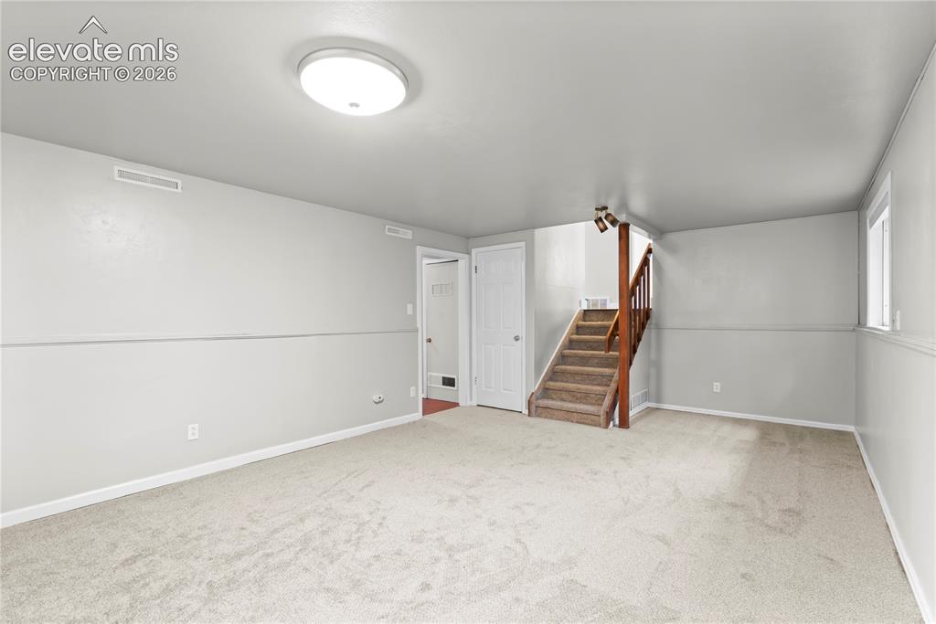 Image 27 of 31: Bonus room featuring built in book shelves and fireplace