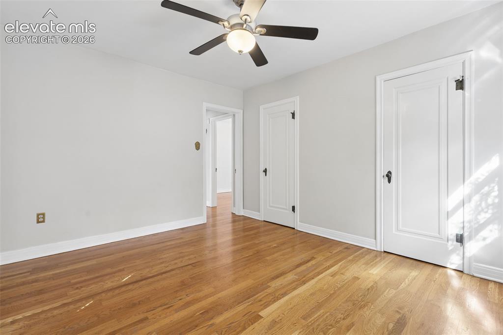 Image 19 of 50: Hardwood flooring with a natural finish, white painted walls, and a ceiling