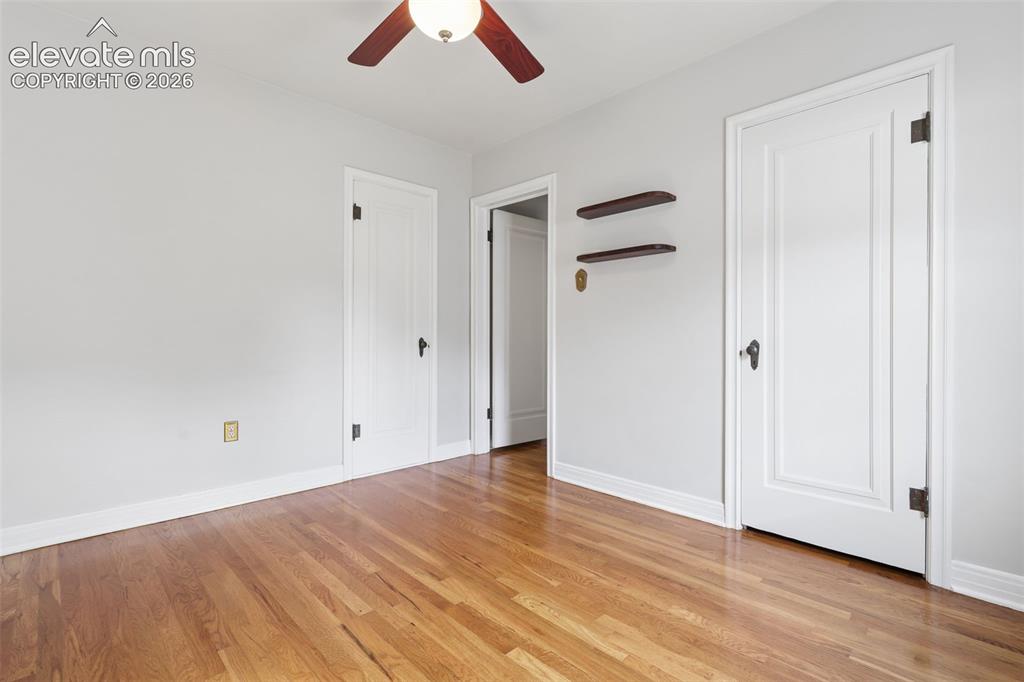 Image 22 of 50: Hardwood flooring, painted walls, white trim, white paneled doors, and a ce