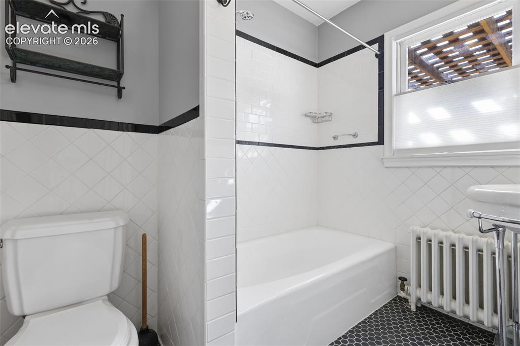 Image 26 of 50: White subway tile surround with black accent trim