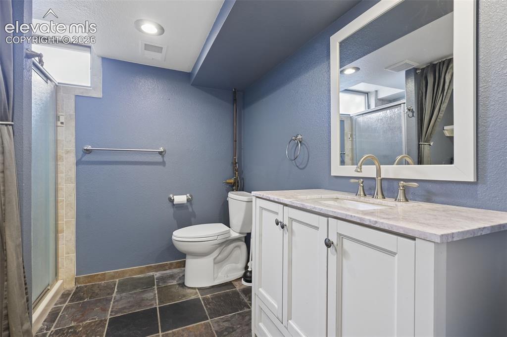 Image 35 of 50: White vanity with a light-toned countertop, brushed nickel fixtures, and a
