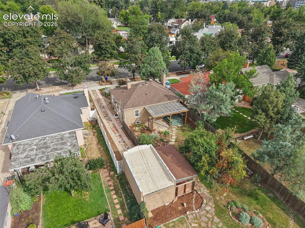 Image 47 of 50: Expansive lot featuring a detached garage, established trees, and a covered
