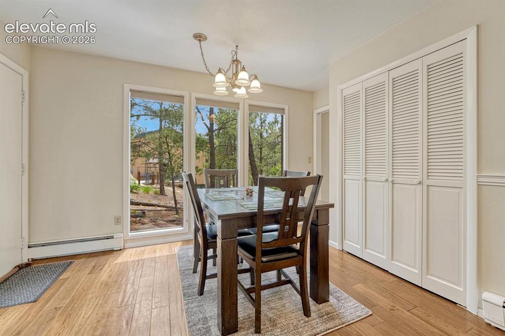 Image 13 of 48: Dining area featuring wood-finish flooring, a contemporary chandelier, and