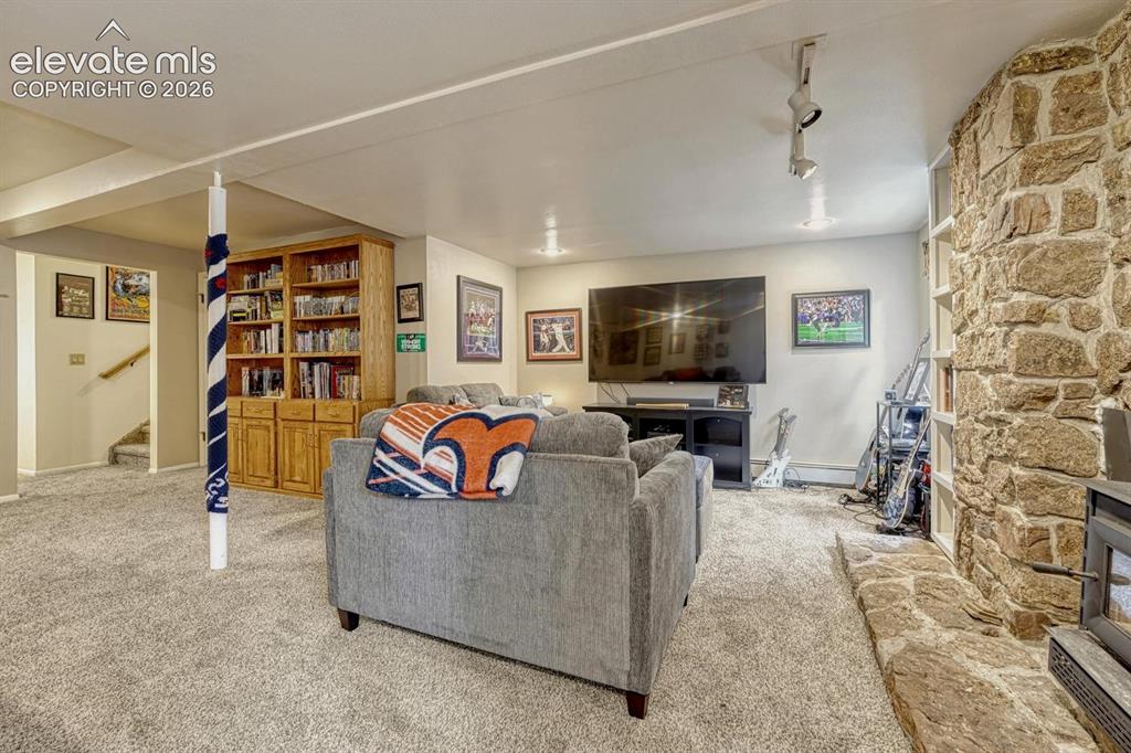 Image 18 of 48: Lower level living space featuring plush carpeting, a stone-clad accent wal