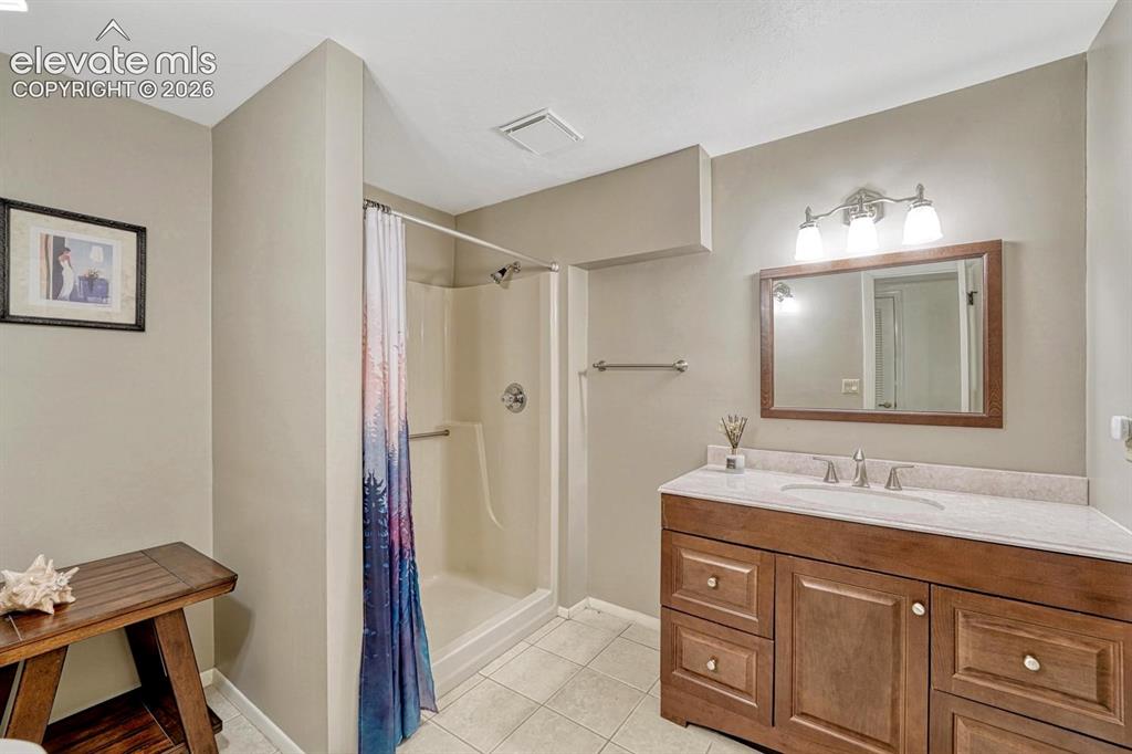 Image 19 of 48: Bathroom featuring a single-sink vanity with a light-colored countertop and
