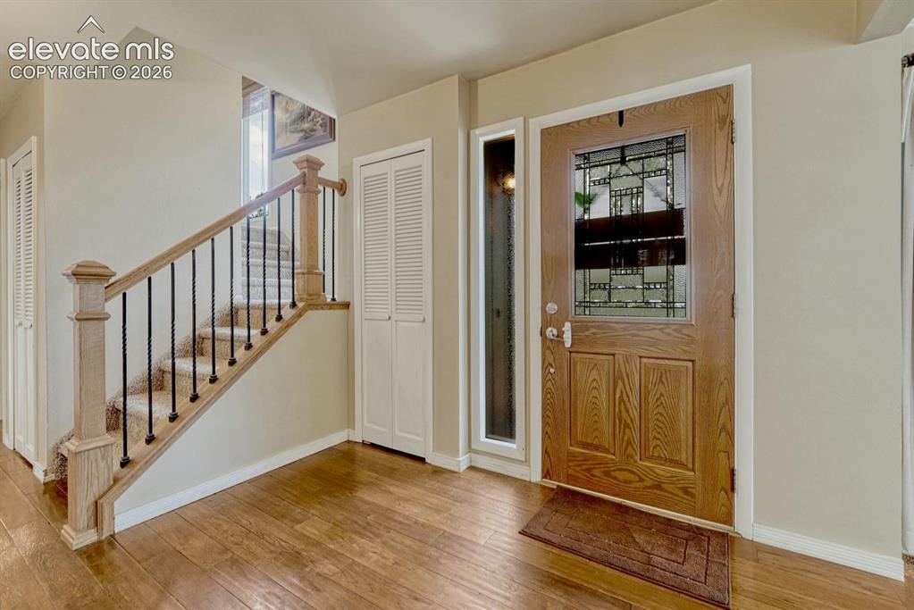 Image 2 of 48: Entryway featuring wood-finish flooring, a wood front door with leaded glas