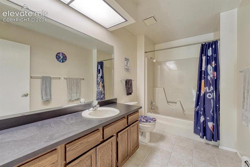 Image 25 of 48: Bathroom featuring an extended vanity with a single sink, wood-finish cabin