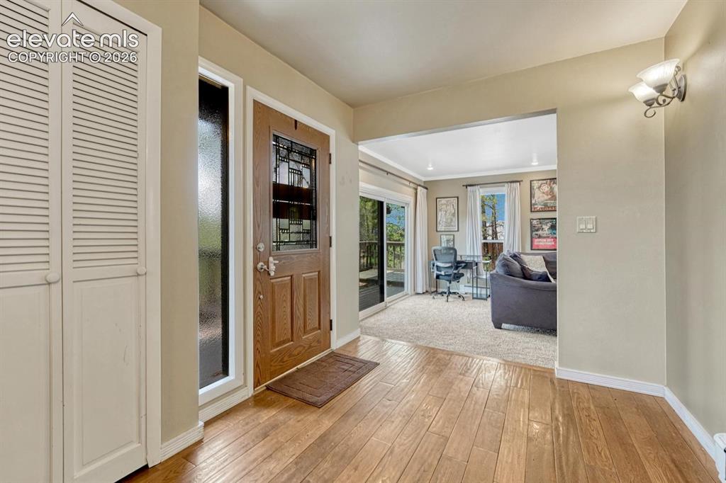 Image 3 of 48: Entryway featuring wood-finish flooring, a decorative wood door with staine