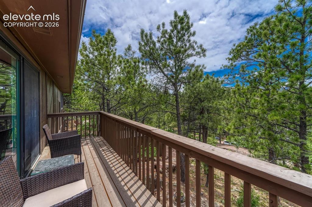 Image 32 of 48: Outdoor deck with wood flooring and railing, featuring a sliding glass door