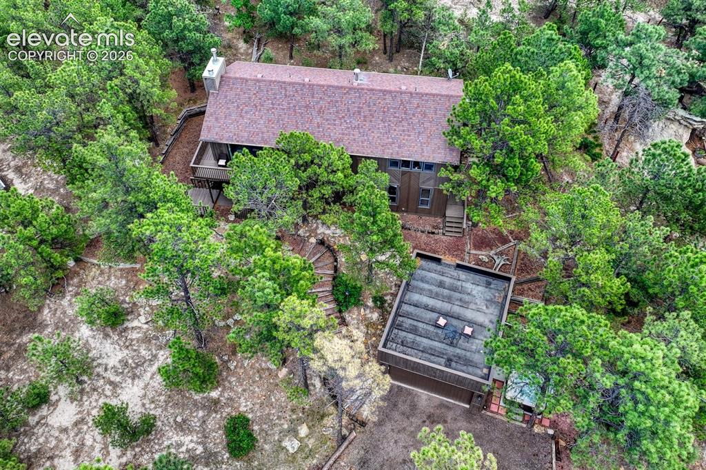 Image 42 of 48: Wood-sided residence featuring a brown shingle roof, a multi-level deck, an