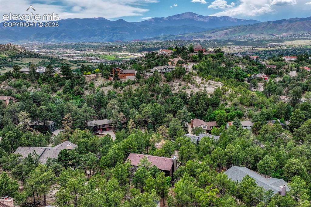 Image 45 of 48: Expansive mountain landscape featuring a community nestled among mature tre