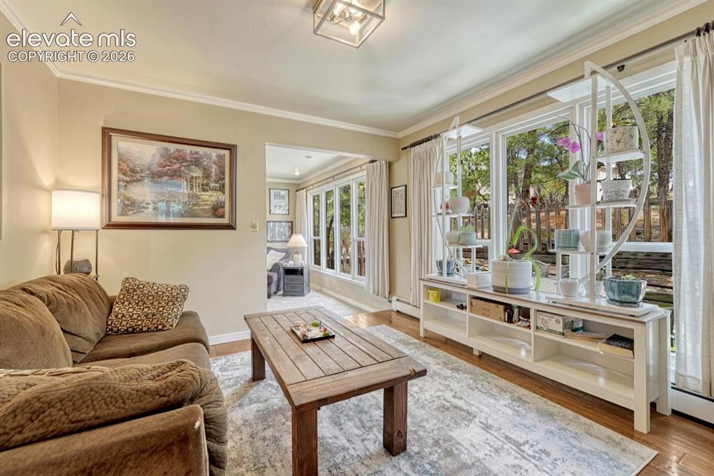 Image 7 of 48: Warmly toned living space featuring wood-finish flooring,