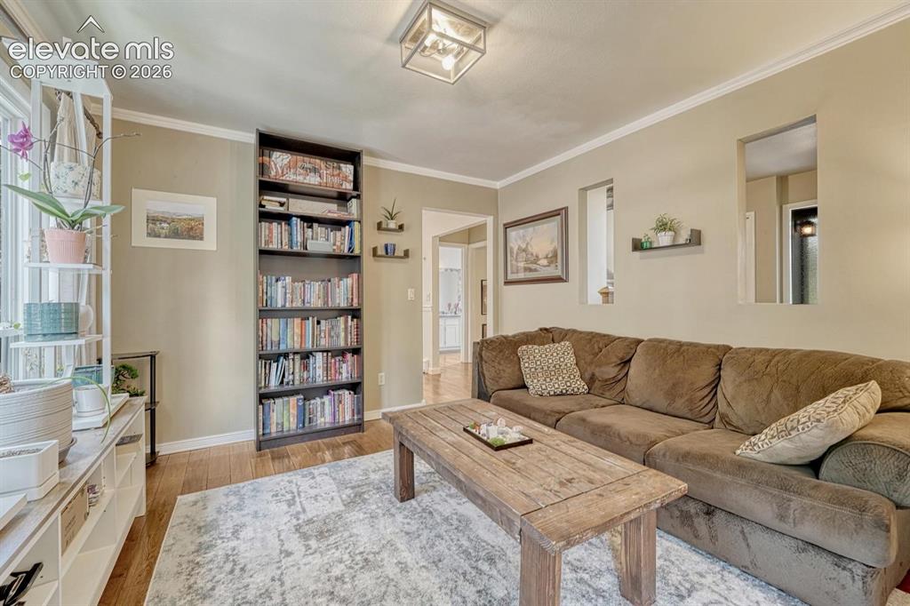 Image 8 of 48: Warmly toned living space featuring wood-finish flooring, a full-height bui