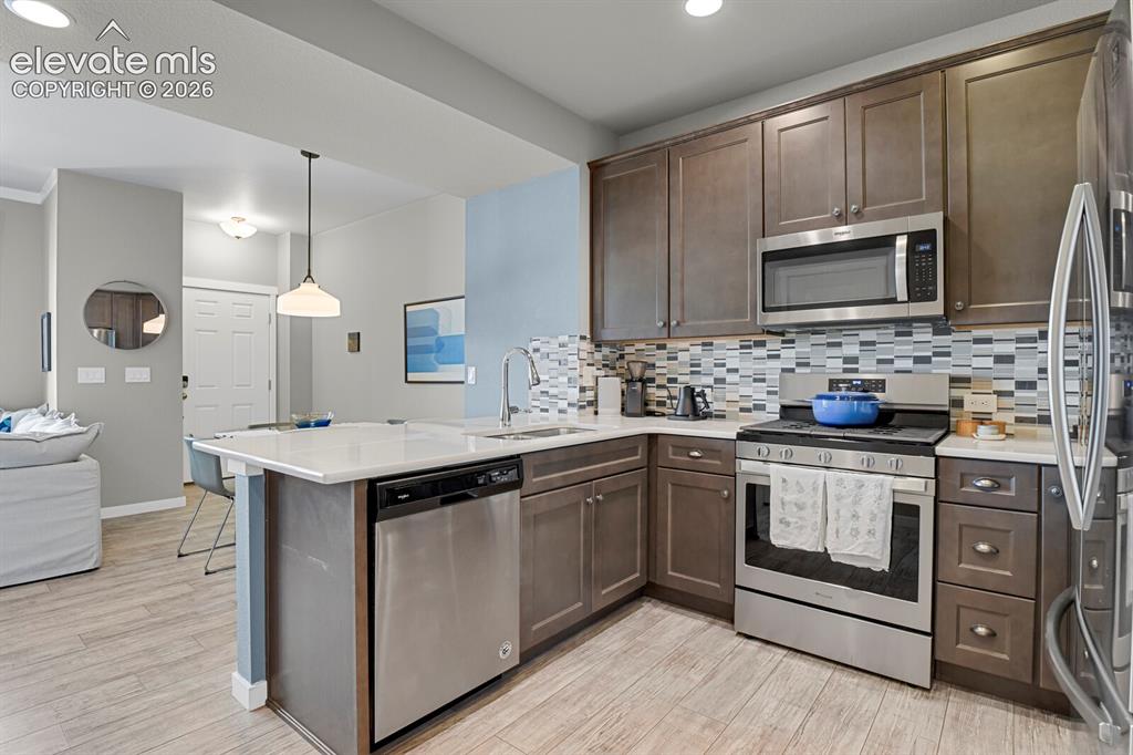 Image 9 of 26: Stainless Steel appliances, gas range and beautiful backsplash