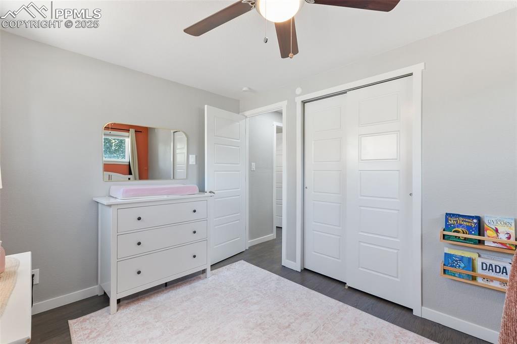 Image 15 of 39: Bedroom featuring dark wood-style floors, a closet, and a ceiling fan