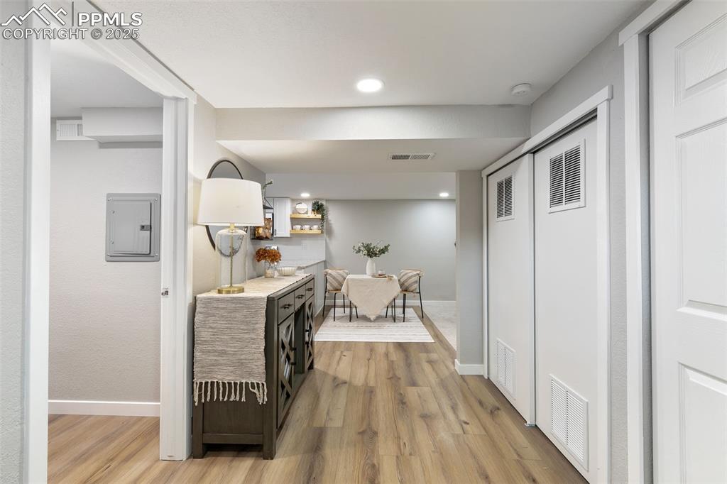 Image 19 of 39: Corridor featuring light wood finished floors, electric panel, and recessed