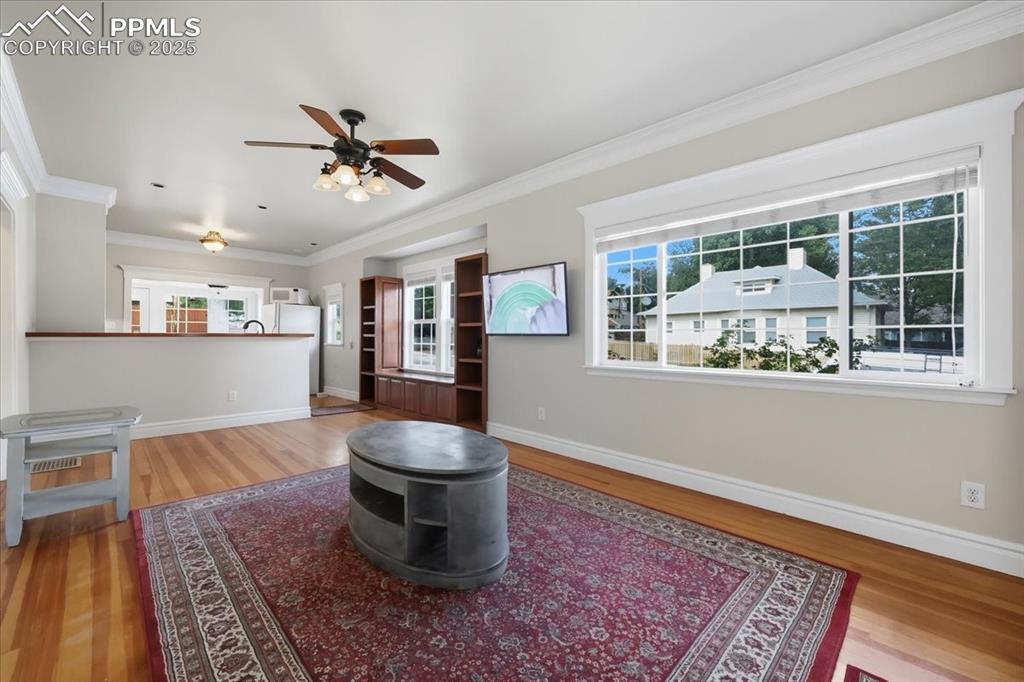 Image 9 of 48: Living room with crown molding, updated windows and tons of sunlight.