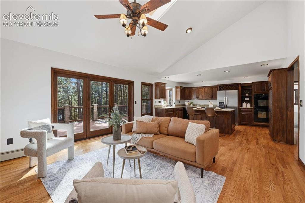 Image 14 of 46: Vaulted white ceiling, wood-finish flooring, built-in double oven, and stai