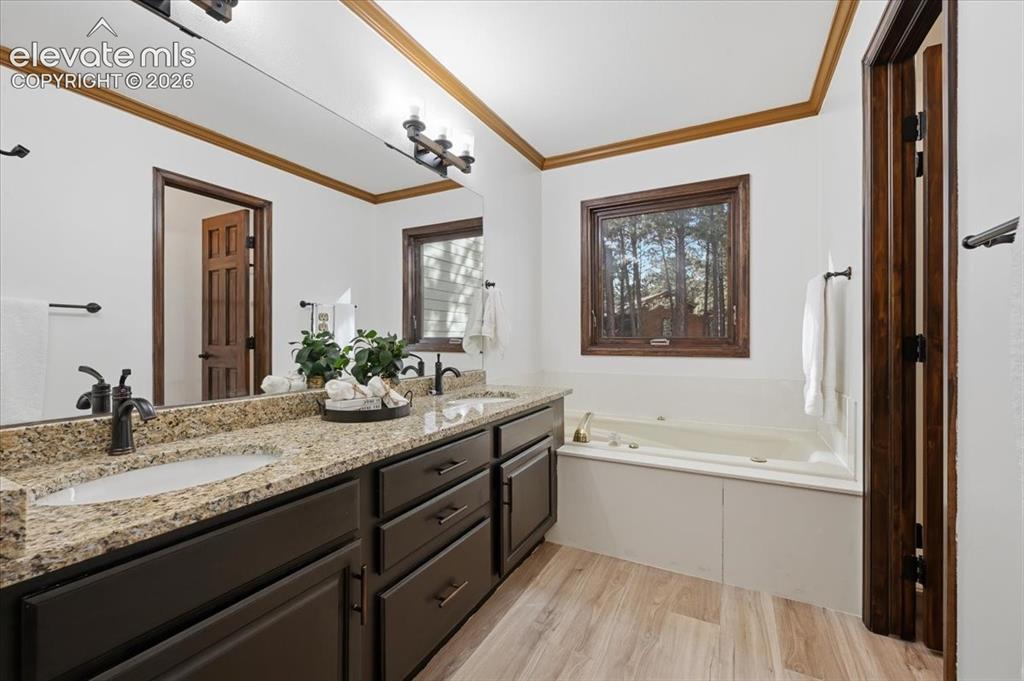 Image 18 of 46: Dual vanity with granite countertop and undermount sinks, bronze fixtures, 