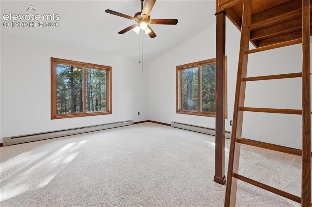Image 21 of 46: Vaulted ceiling with a ceiling fan, white wall paint, two large windows wit