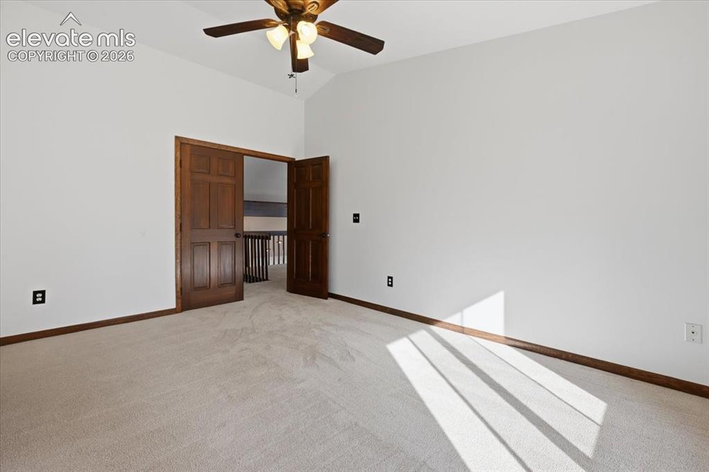 Image 24 of 46: Vaulted ceiling featuring a ceiling fan with integrated lighting, wood-fini