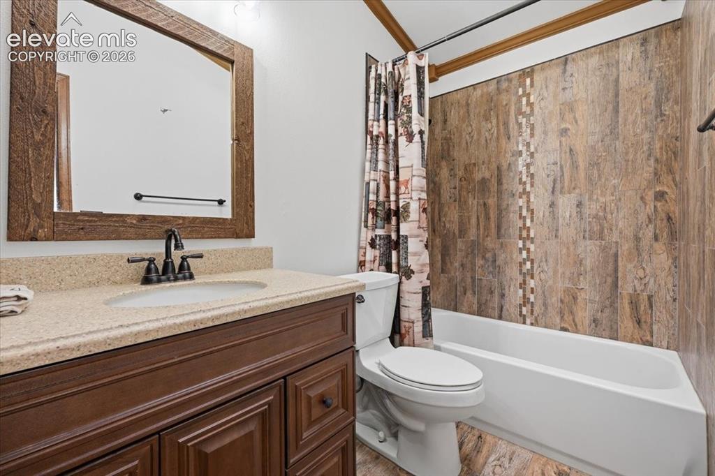 Image 25 of 46: Vanity with a light-colored countertop, dark wood-finish cabinetry, and a r
