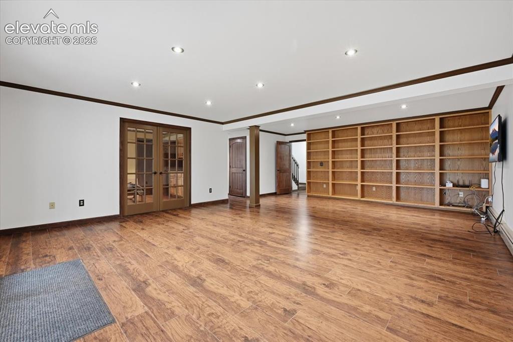 Image 27 of 46: Spacious room featuring wood-finish flooring, recessed lighting, built-in s