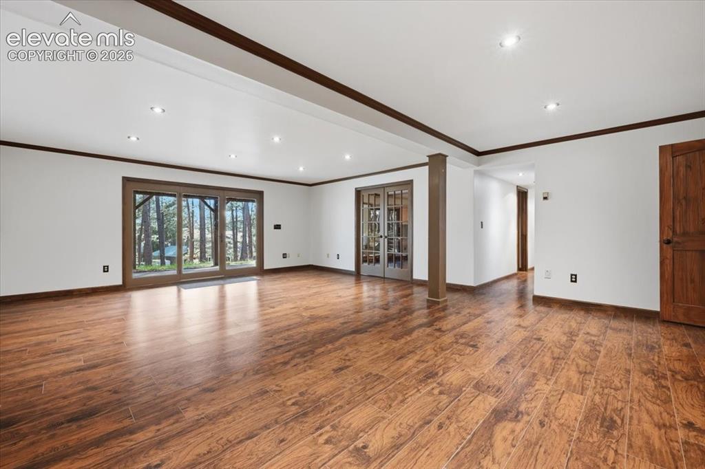 Image 28 of 46: Expansive interior with wood-finish flooring, recessed lighting, and white 