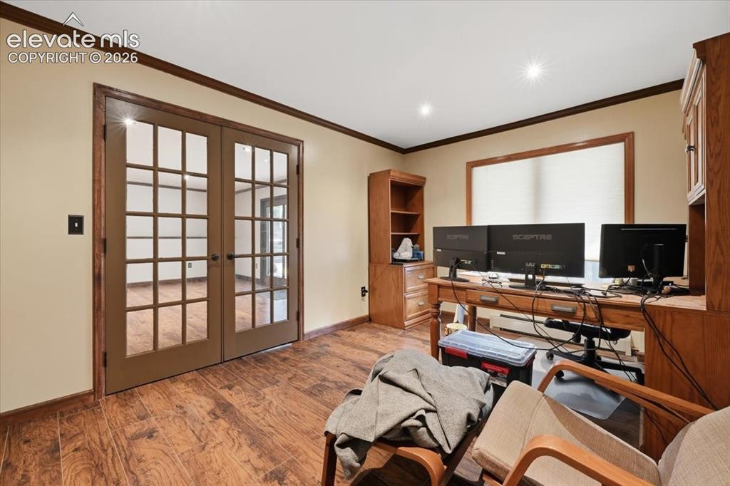 Image 29 of 46: Wood-finish flooring with dark trim, recessed lighting, and a large window