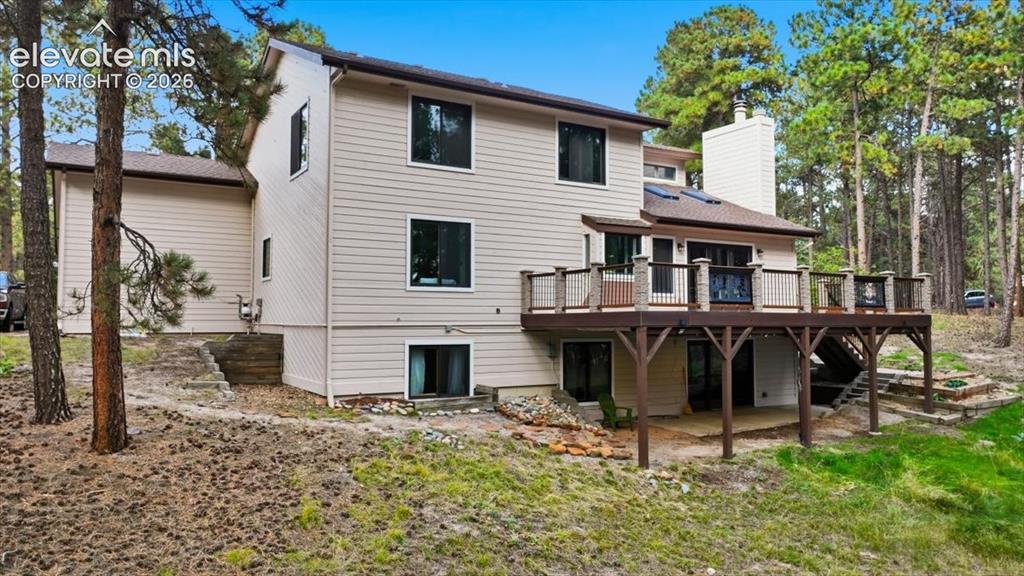 Image 42 of 46: Multi-level exterior with light-colored siding, a brown shingle roof, and m