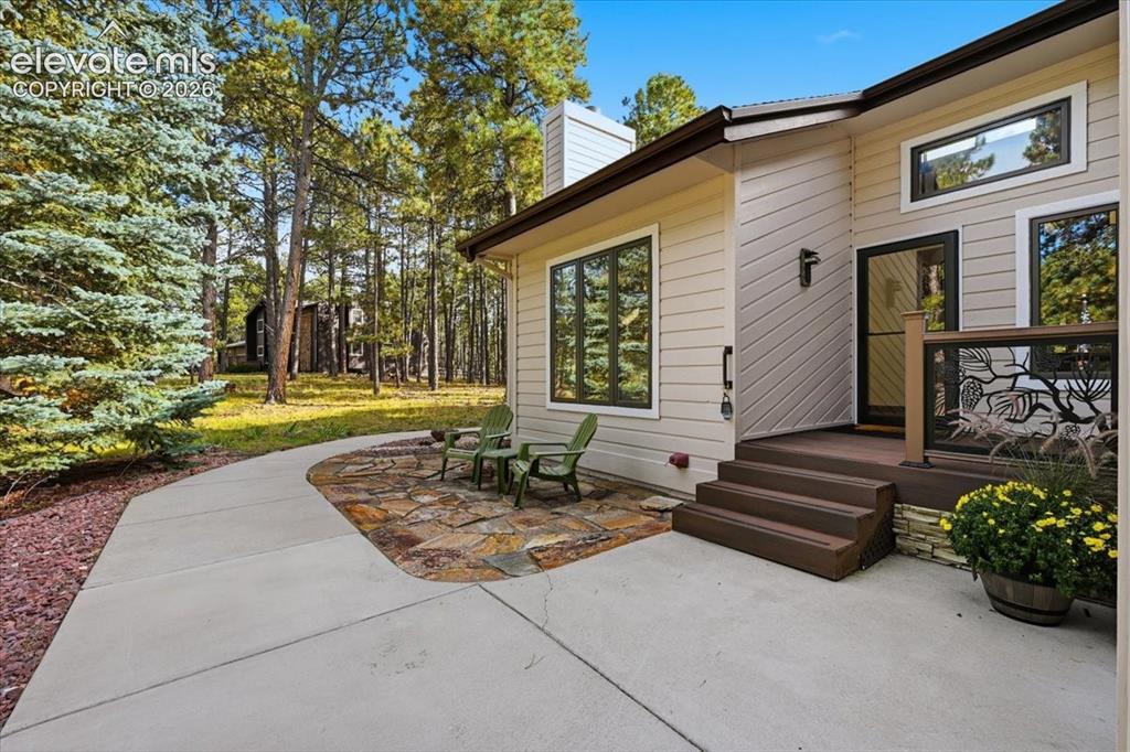 Image 6 of 46: Exterior siding, multi-pane windows, wood-finish porch with railing, stone