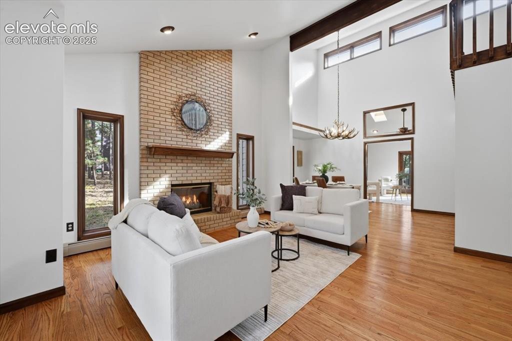 Image 7 of 46: Vaulted ceilings with exposed beams, brick-faced fireplace with wood mantel