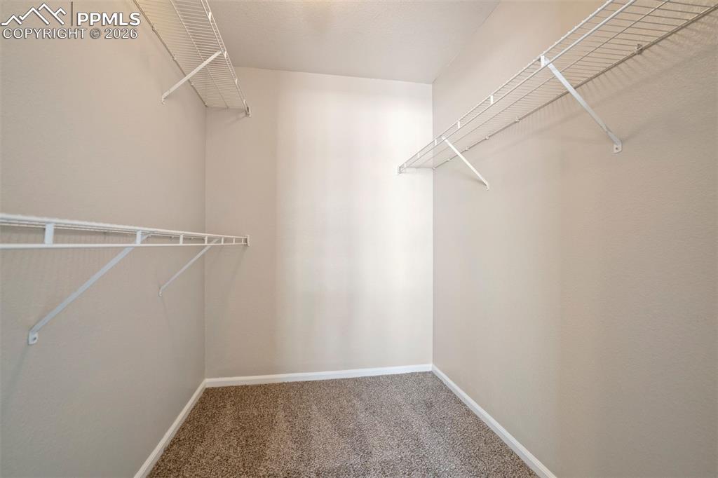 Image 20 of 31: Primary walk-in closet for the wardrobe 