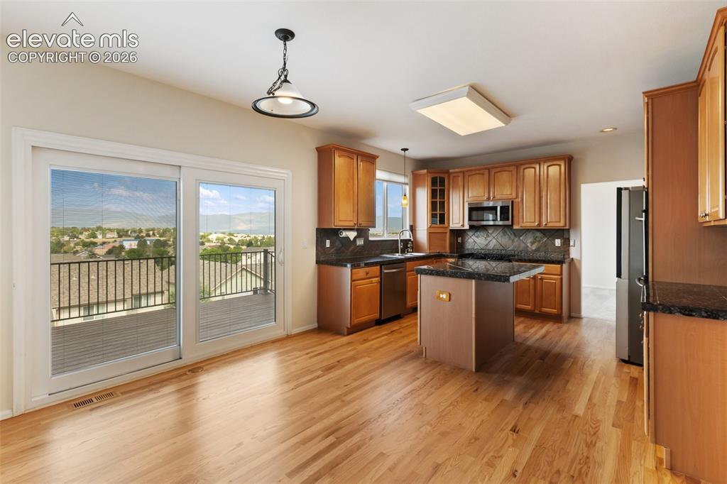 Image 27 of 50: Primary Bedroom with amazing Pikes Peak View and double sided fireplace
