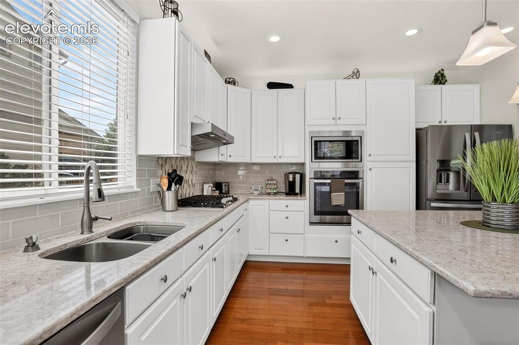 Image 10 of 42: Kitchen featuring white cabinetry, light-toned countertops, stainless steel