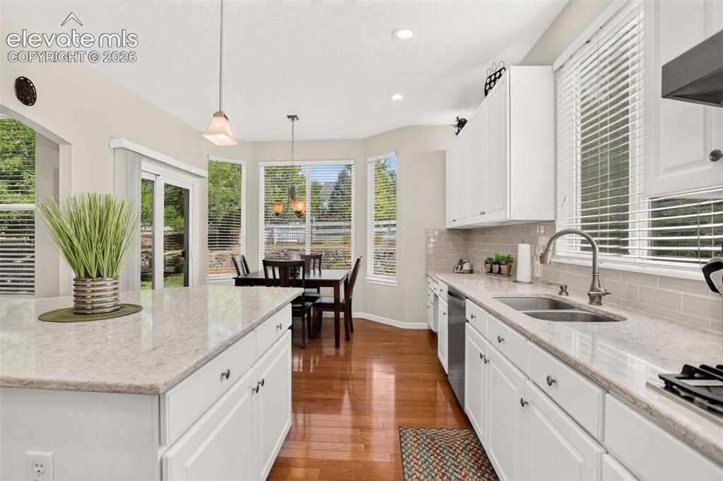 Image 11 of 42: Gourmet kitchen featuring white cabinetry, light-toned countertops, and woo