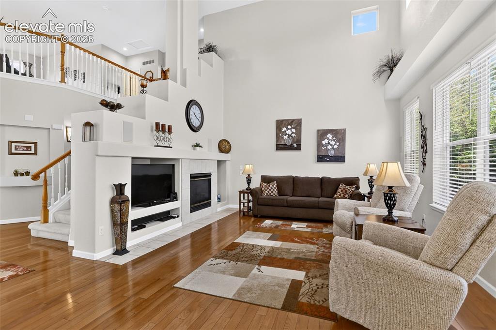 Image 13 of 42: Expansive living area with high ceilings, large windows, wood-finish floori