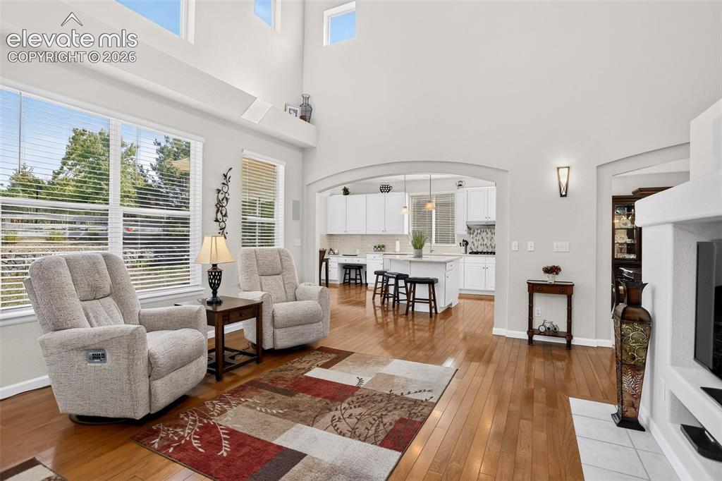 Image 15 of 42: Hardwood flooring, arched doorways, high ceilings, large windows, and an op
