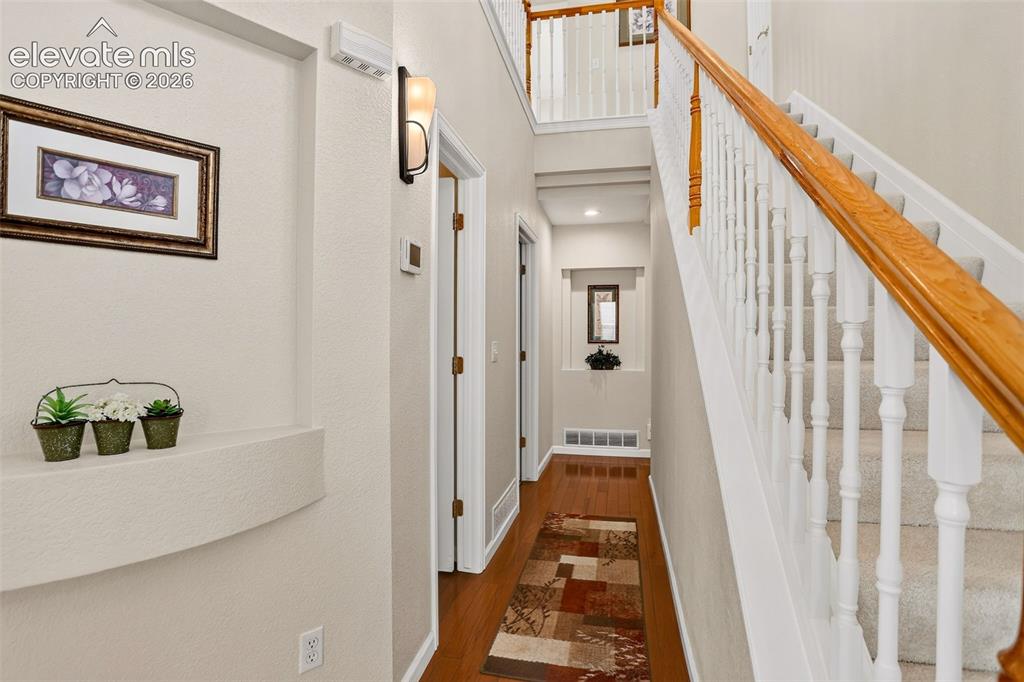 Image 17 of 42: Staircase with light wood-finish handrail and white balusters
