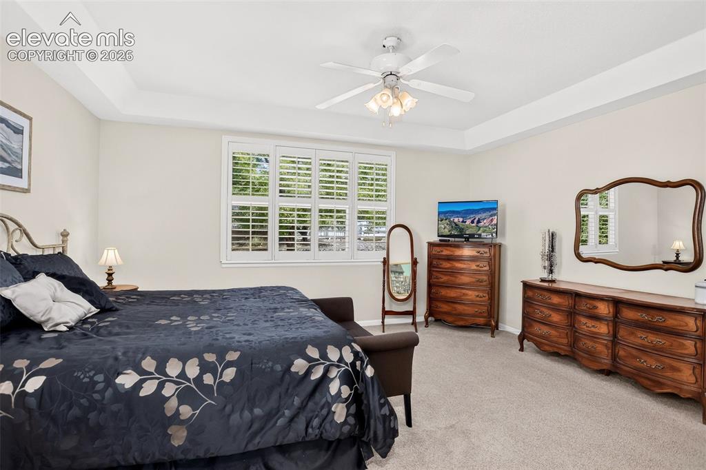 Image 24 of 42: Tray ceiling with recessed lighting, ceiling fan with integrated light fixt