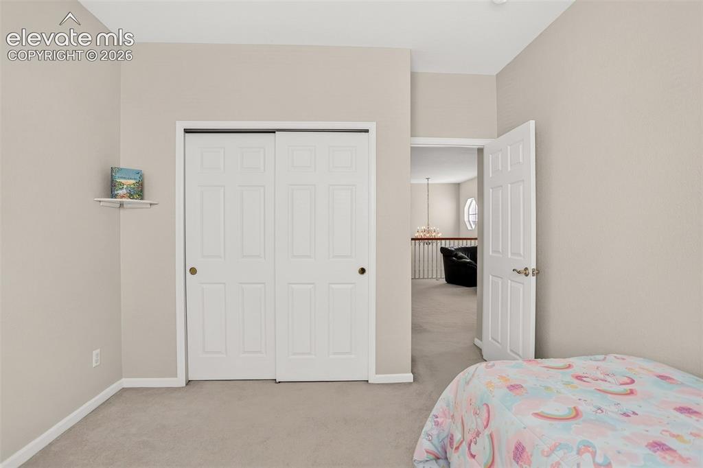 Image 33 of 42: Neutral wall color, carpet flooring, sliding closet doors, and a paneled in
