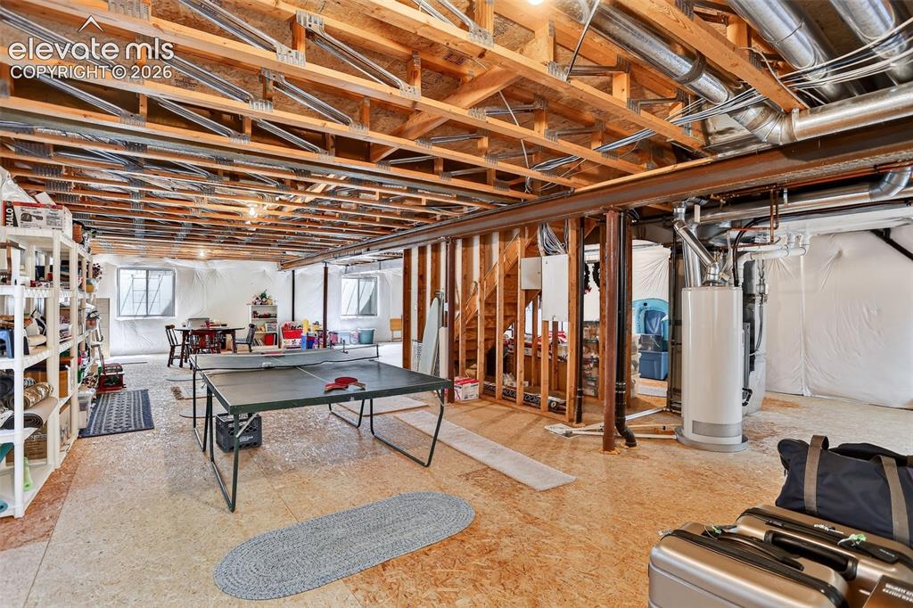 Image 36 of 42: Unfinished basement with exposed wood joists and structural beams