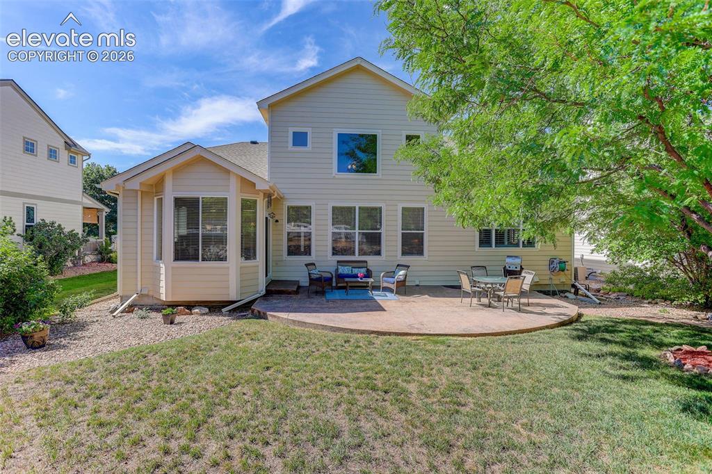 Image 39 of 42: Expansive backyard featuring a curved concrete patio, a bay window extensio