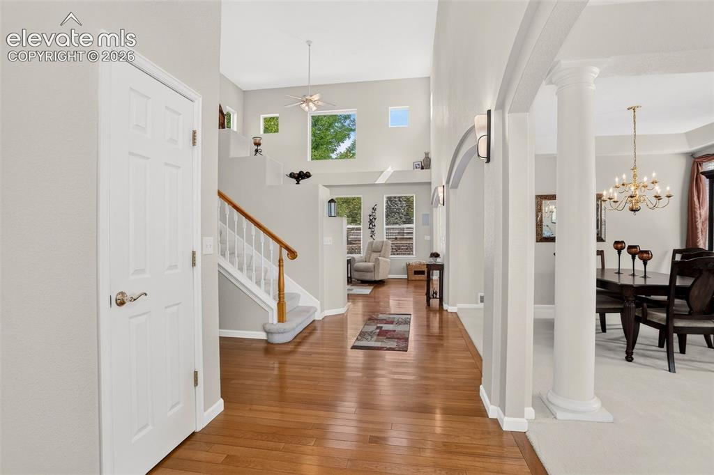 Image 4 of 42: Hardwood flooring, arched entryway, architectural columns, vaulted ceiling,