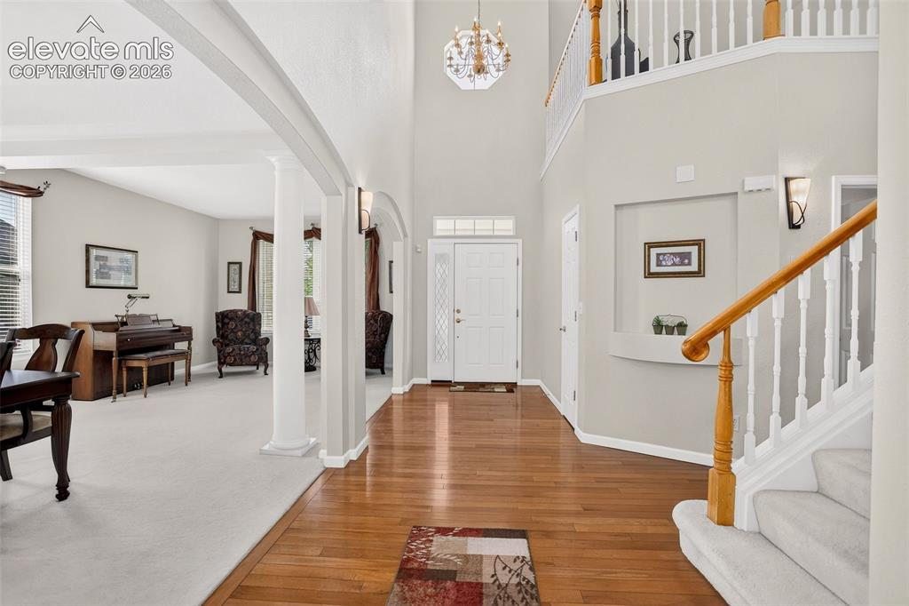 Image 5 of 42: Two-story foyer featuring wood-finish flooring, a decorative chandelier, an